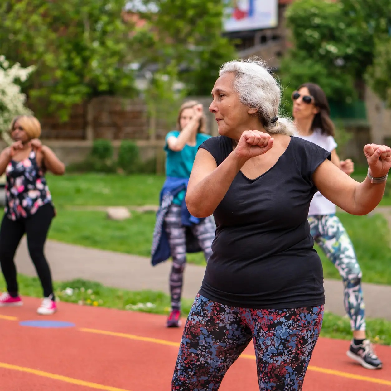 Seniorin beim Gruppentraining auf dem Sportplatz